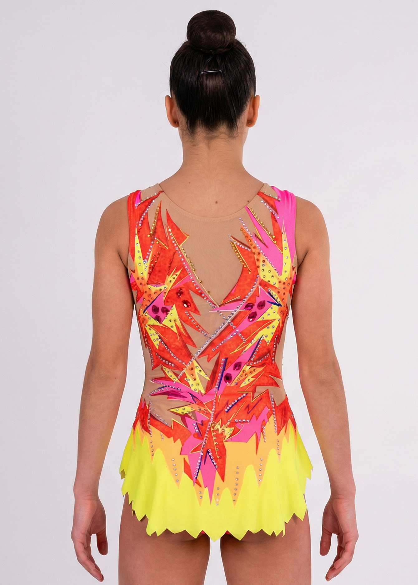 Maillot de gimnasia rítmica en rojo, rosa y amarillo con pedrería, transparencias simuladas y motivos flameados creando un estilo vibrante.
Maillot de gimnasia rítmica color claro con rojos intensos, detalles amarillos y rosas, pedrería brillante y diseño flameado de aspecto dinámico.
Maillot de gimnasia rítmica visto por la espalda en base clara con rojos, rosas y amarillos, pedrería y trazos flameados fluidos.