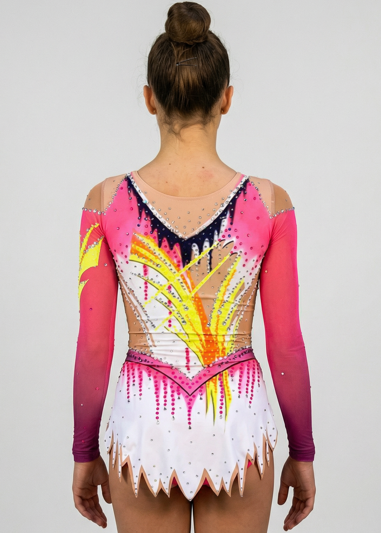 Maillot de gimnasia rítmica en blanco, rosa y amarillo con mangas degradadas, pedrería abundante y motivos flameados creando un estilo vibrante.
Maillot de gimnasia rítmica color claro con rosas intensos, detalles amarillos, pedrería brillante y diseño flameado que aporta un efecto dinámico.
Maillot de gimnasia rítmica visto por la espalda en blanco y rosa con pedrería, degradados y motivos amarillos formando un estilo fluido.