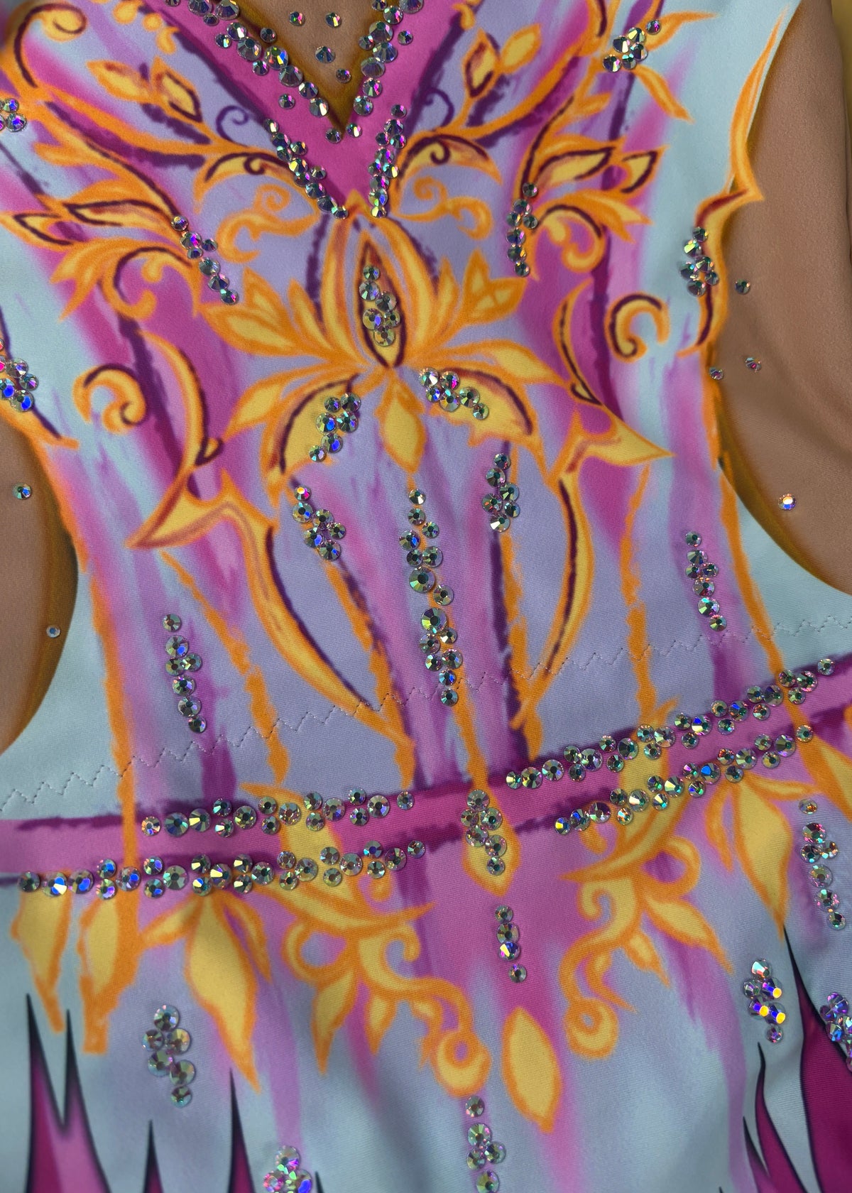 Detail des gelb-orangen Ornaments mit Kristallen im Brustbereich.