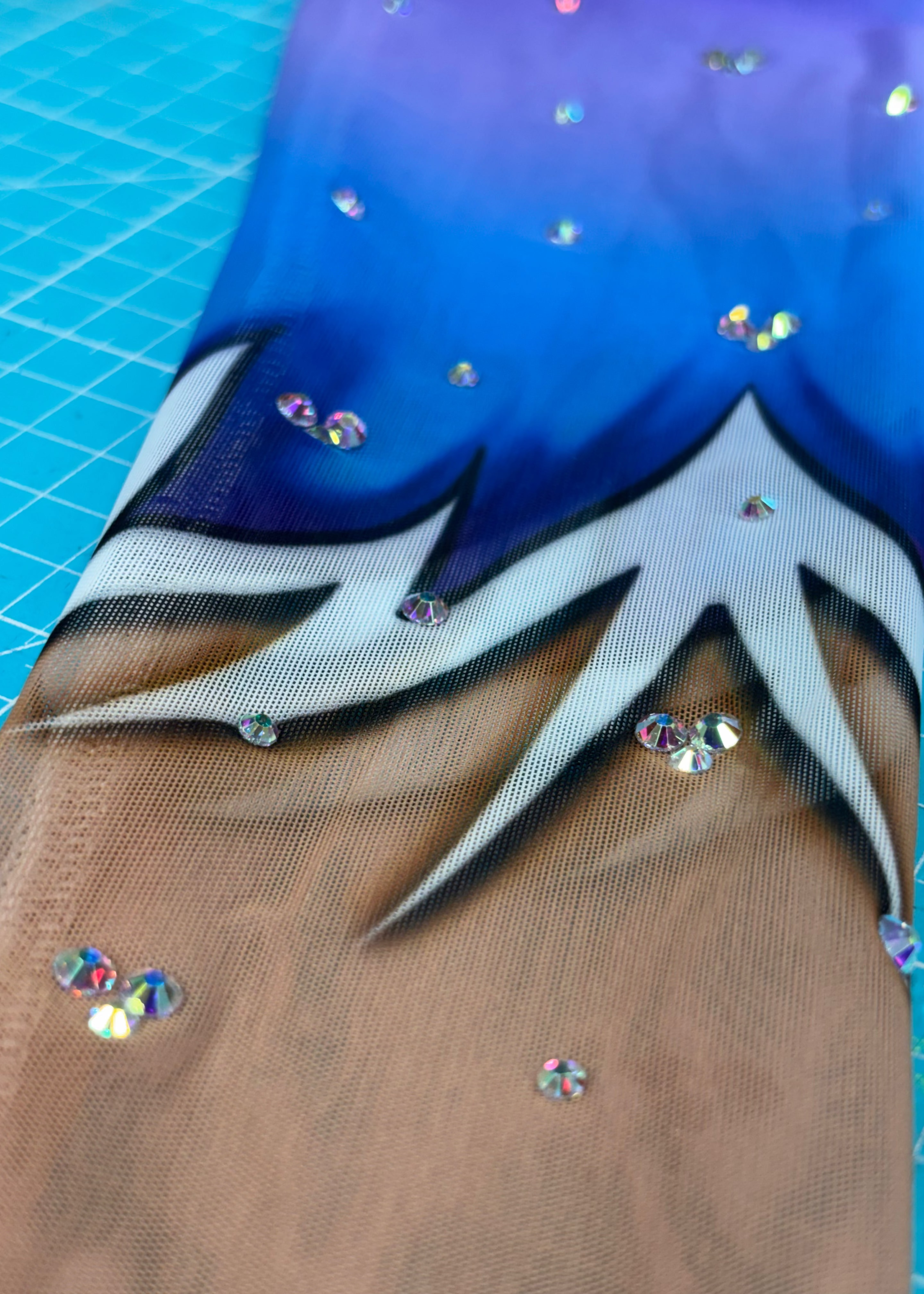 Dalias einzelner langer Ärmel mit Verlauf von Violett zu Blau und kleinen Glanzdetails.