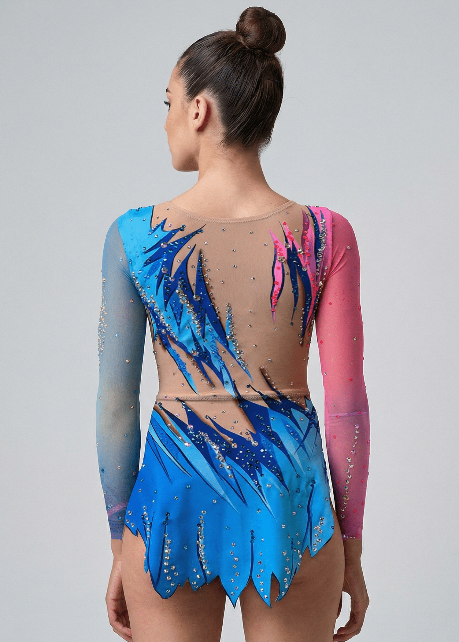 Maillot de gimnasia rítmica azul y rosa con degradados, transparencias tono piel, pedrería abundante y mangas largas en estilo dinámico.
Maillot rítmico en azules y rosas con diseño flameado, transparencias tono piel, pedrería brillante y falda recortada de acabado en movimiento.
Espalda del maillot rítmico azul y rosa con degradados, transparencias tono piel, pedrería dispersa y diseño estilizado de líneas ascendentes.
