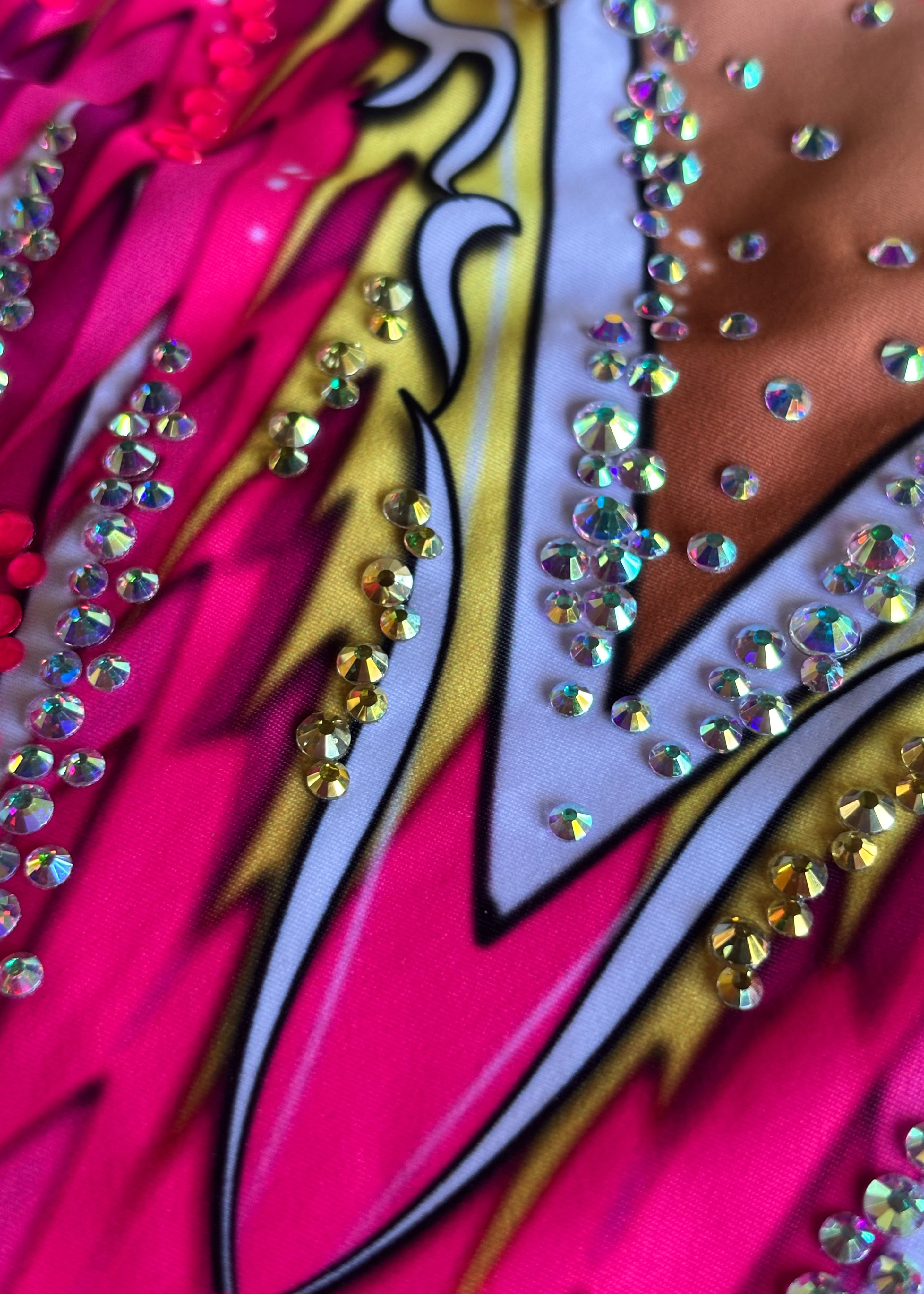 Maillot profesional de gimnasia rítmica con cristales y motivos en fucsia, blanco y oro.