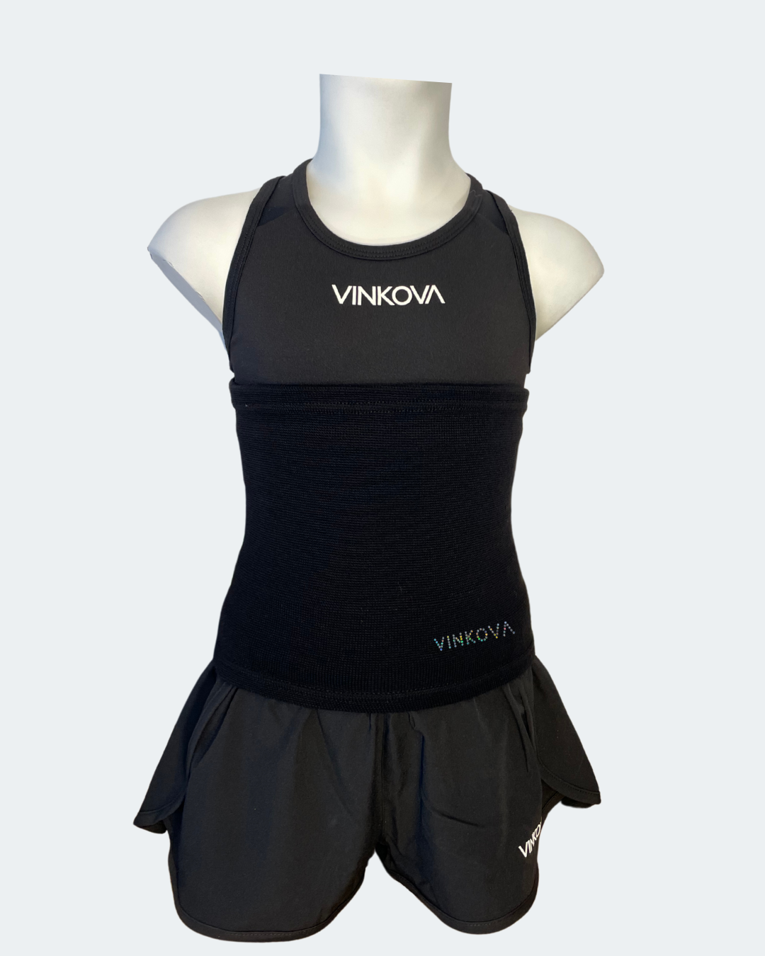 Vinkova Nierenwärmer in schwarz an einer Schaufensterpuppe mit schwarzem Outfit.