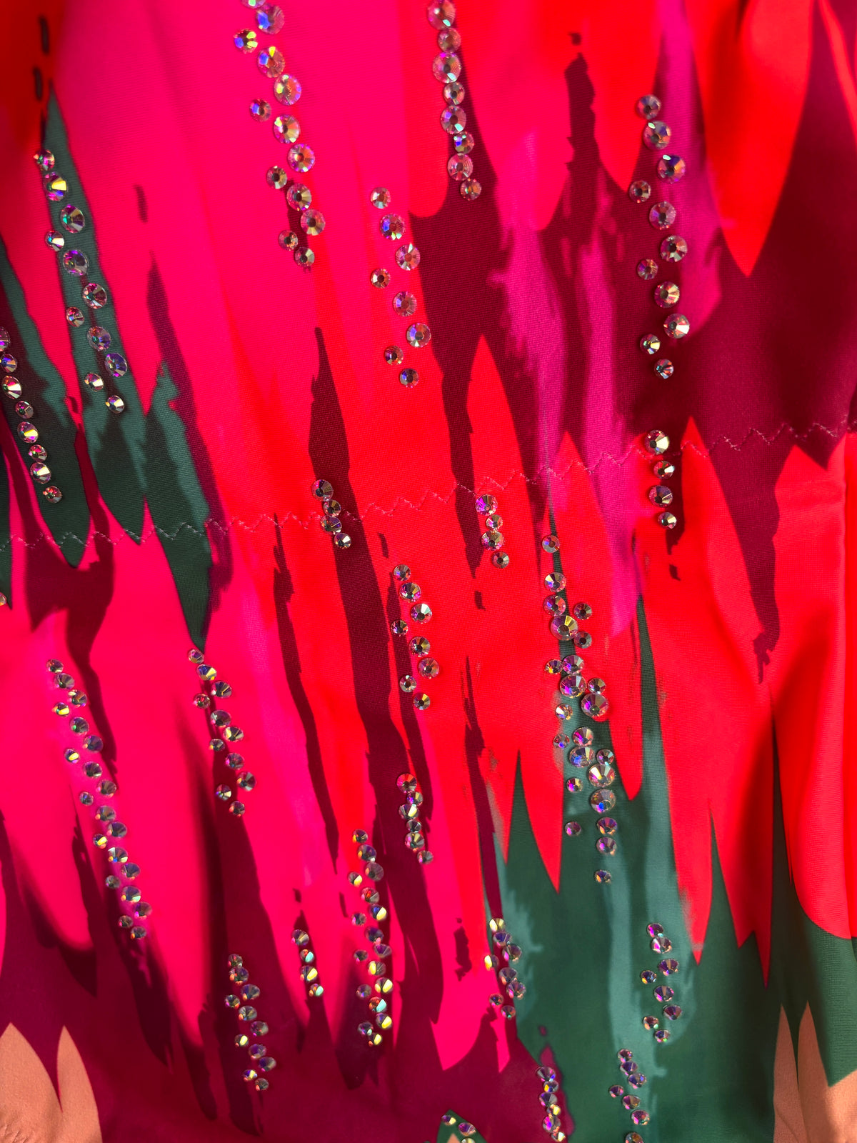 Nahaufnahme von Matisse mit Glanzsteinlinien auf fuchsia-, rot- und dunkelgrünen Formen.