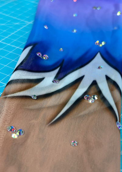 Dalias einzelner langer Ärmel mit Verlauf von Violett zu Blau und kleinen Glanzdetails.