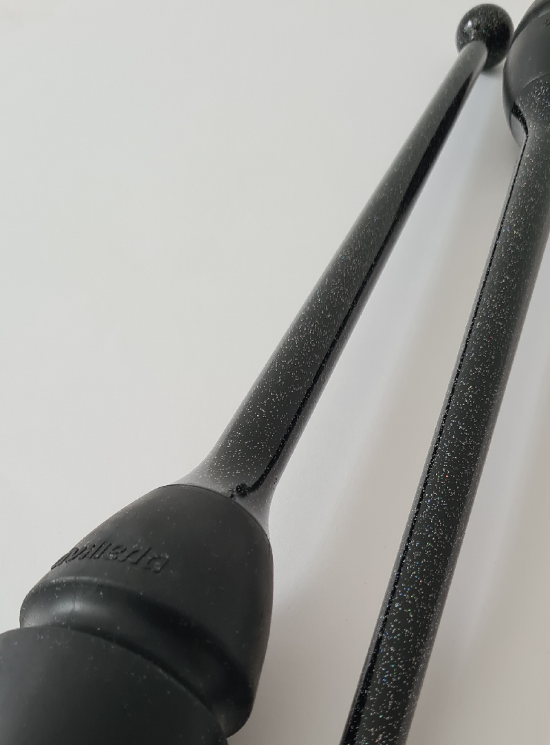 Zwei RSG-Keulen; Körper in Schwarz mit Glitter und Köpfe in Schwarz; Detailaufnahme der Köpfe und der Glitteroberfläche auf hellem Hintergrund.