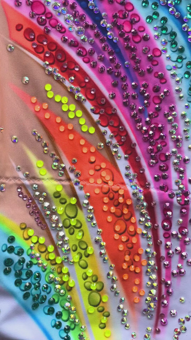 Maillot profesional elástico con falda de picos rosa y brillantes de colores.